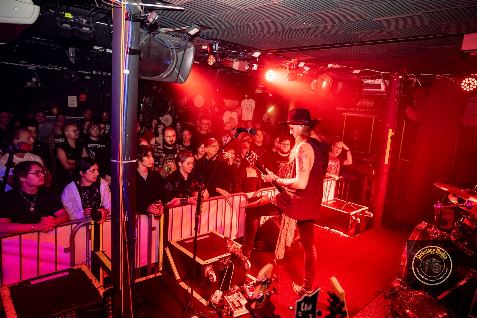 The Better Dead performing in front of a packed audience under red stage lighting
